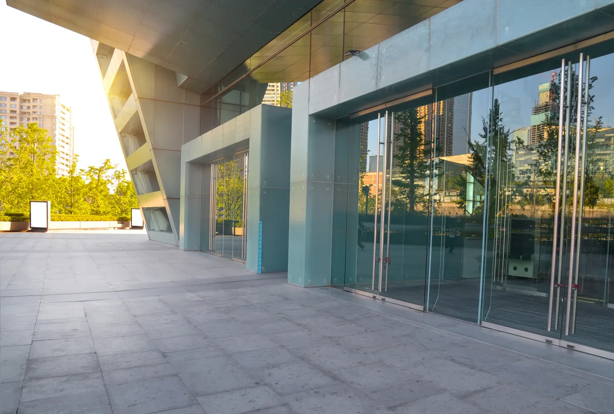 Commercial building lobby entrance with access control integration, turnstile visible