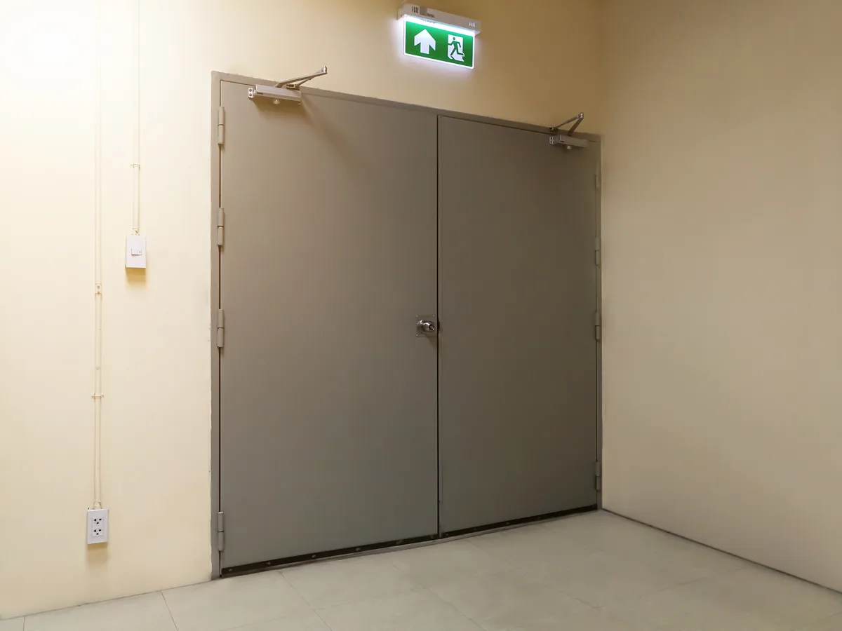 Fire-rated door with push-bar hardware in a commercial building corridor