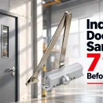 Silver door closer with articulated arm beside a gray industrial door, with bold text reading Industrial Door Closer Samples: 7 Tests Before Bulk Orders.